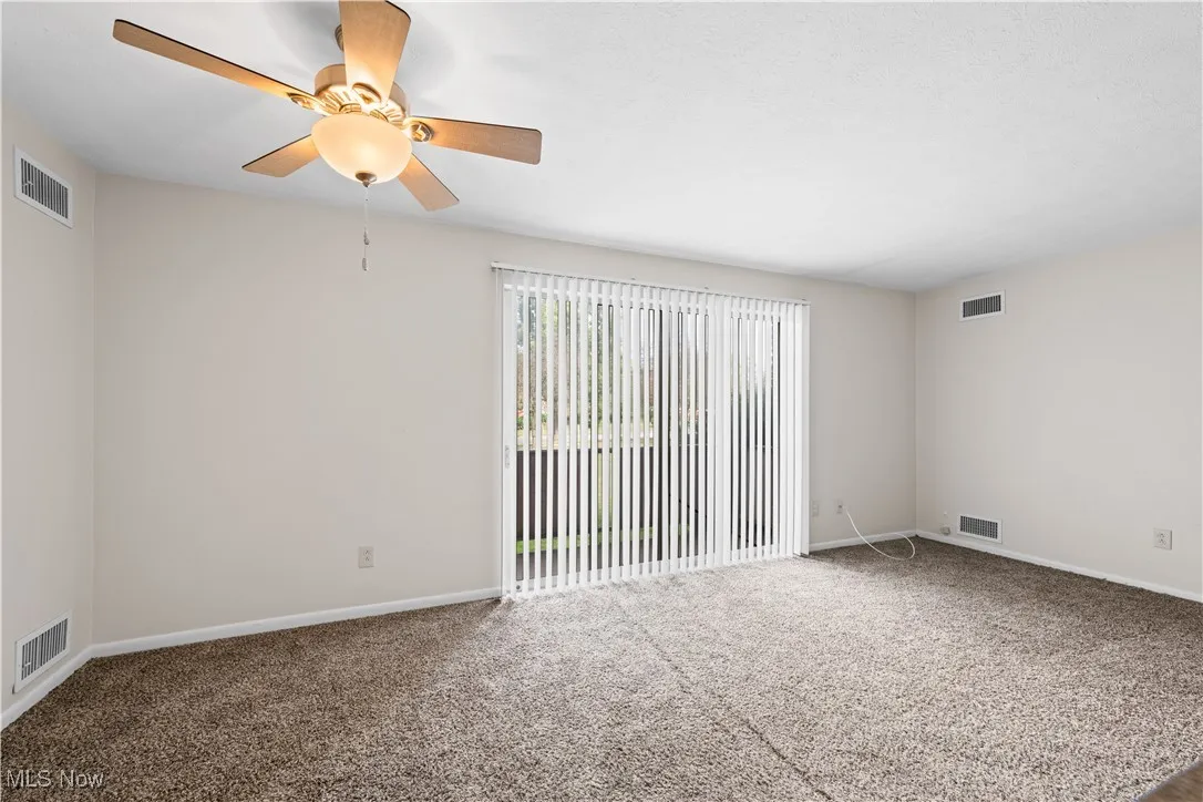 Carpeted dining area with a ceiling fan