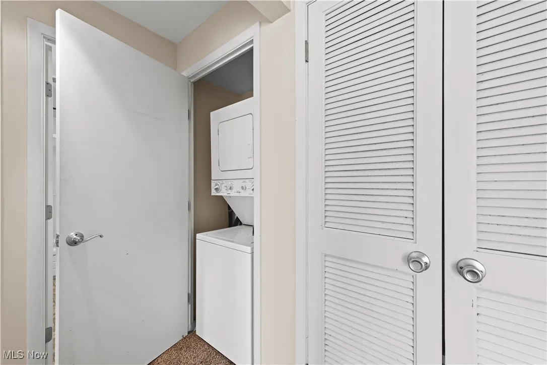 In unit laundry closet with stacked washer and clothes dryer