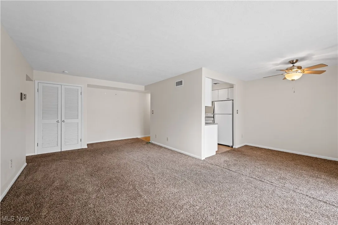 Unfurnished living room featuring light carpet
