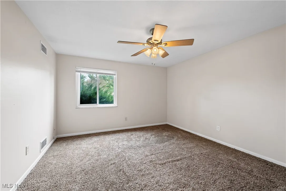 Carpeted bedroom featuring a ceiling fan and baseboards
