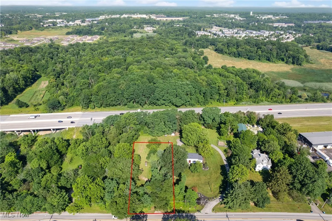 Aerial overview of property's location featuring property boundaries highlighted and a heavily wooded area