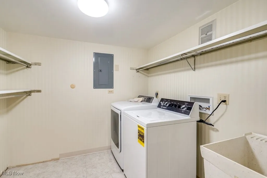Laundry area featuring electric panel and washing machine and dryer
