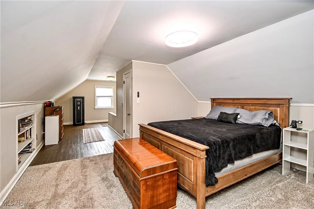 Bedroom featuring wood finished floors and vaulted ceiling