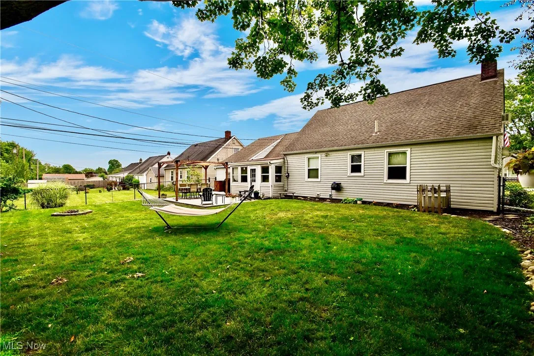 Rear view of property with a fenced backyard, a chimney, a patio, and a shingled roof