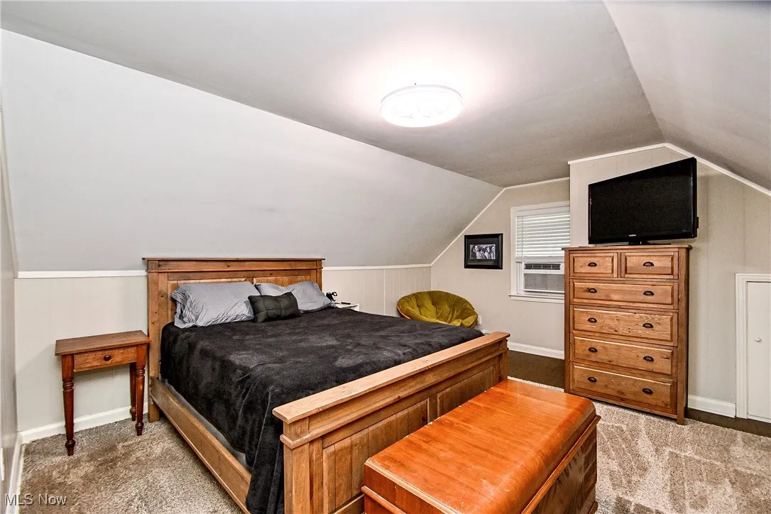 Bedroom with carpet floors, vaulted ceiling, and cooling unit