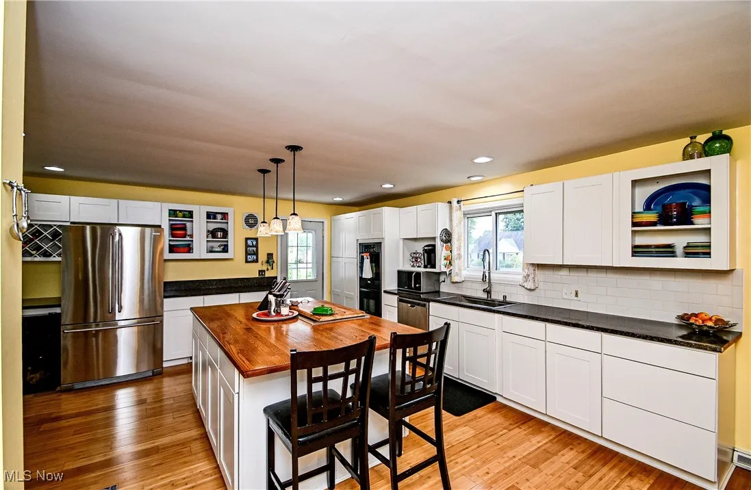 Kitchen featuring appliances with stainless steel finishes, wooden counters, plenty of natural light, light wood-type flooring, and recessed lighting