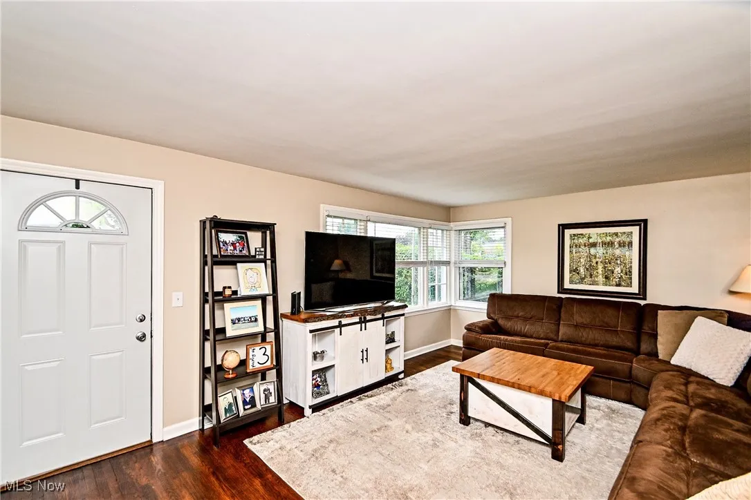 Living area with dark wood-style floors and baseboards