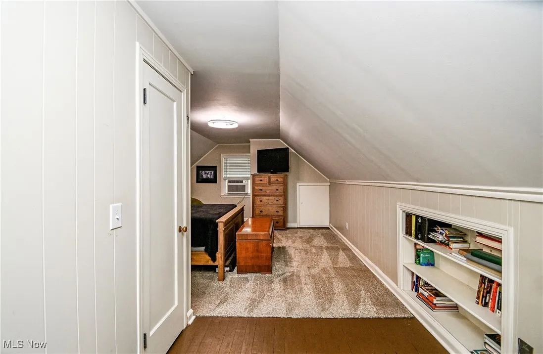 Office area featuring wood finished floors, cooling unit, and lofted ceiling