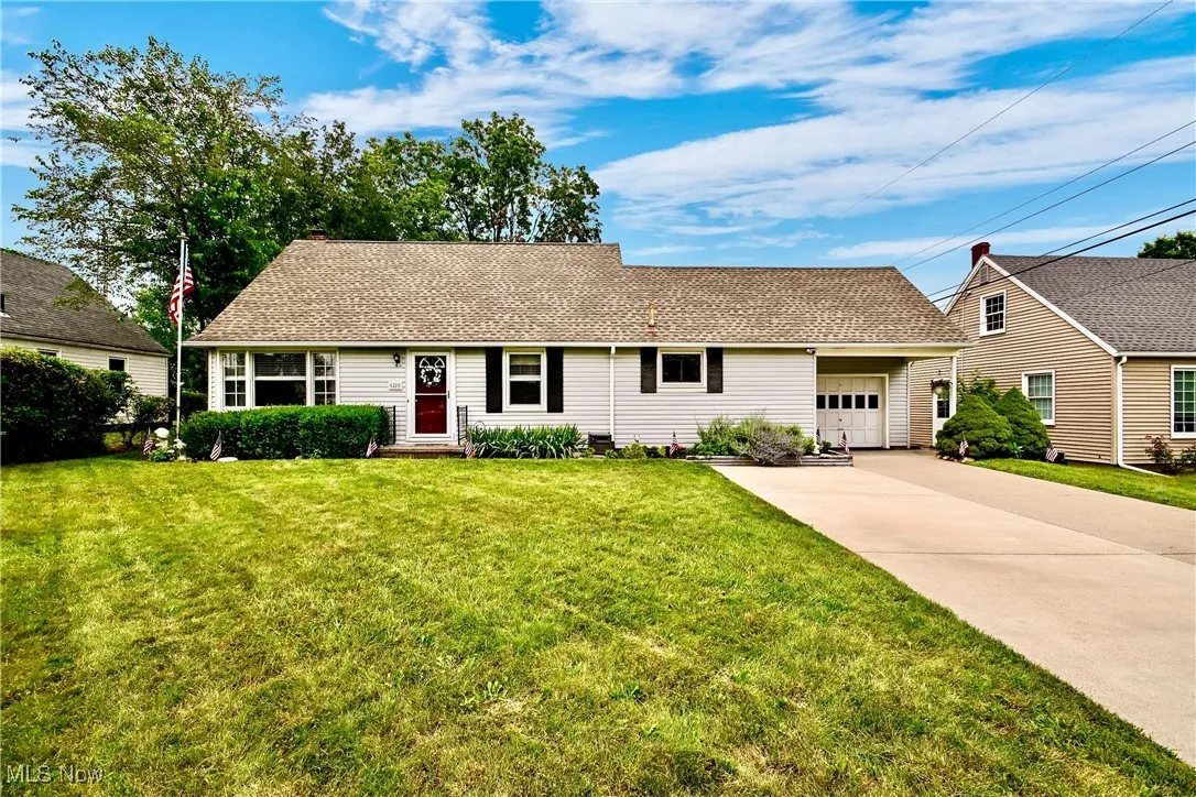 View of front of home with a garage, concrete driveway, a front lawn, and a shingled roof