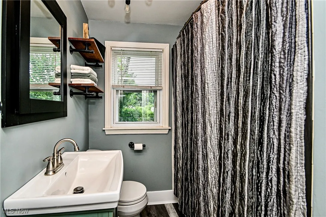 Bathroom with vanity, and curtained shower/tub