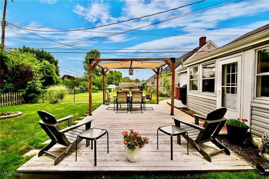 Wooden deck with outdoor dining space and a fenced backyard