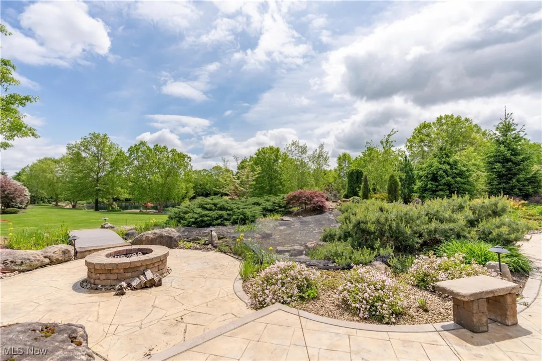 Impeccable landscaping and brick firepit.
