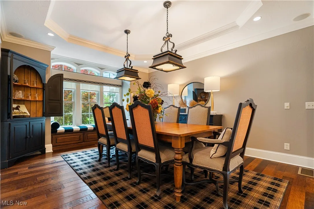 Front formal dining room with dual chandeliers and a window seat space.
