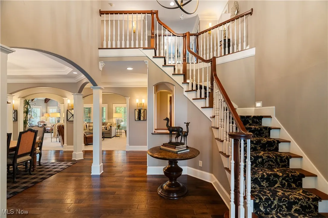 Gorgeous entryway featuring ornate columns, crown molding, and arched walkways.