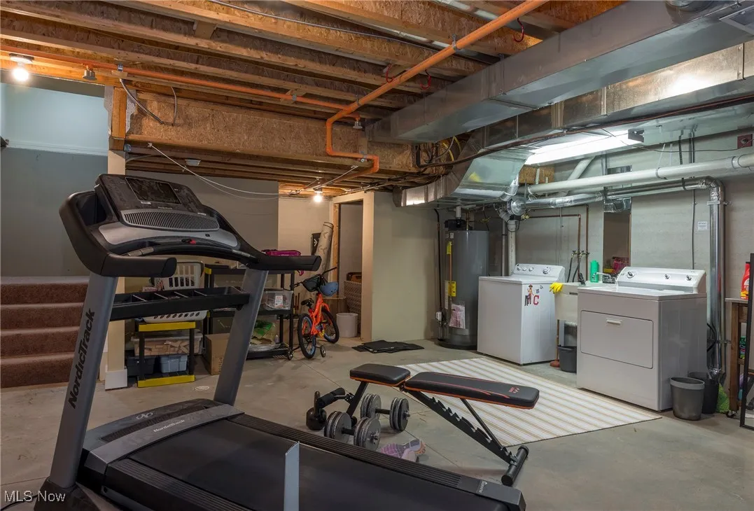 Workout room featuring washing machine and dryer and gas water heater