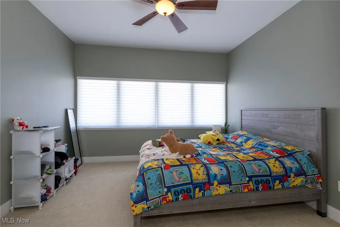 Bedroom featuring carpet flooring, multiple windows, and a ceiling fan
