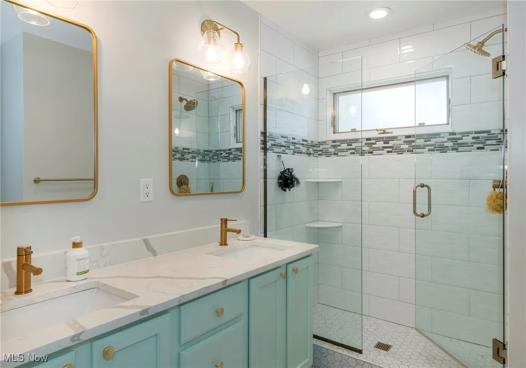 Bathroom featuring a stall shower and double vanity