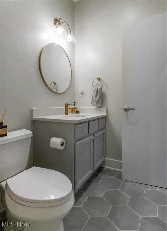 Half bath with vanity and tile patterned flooring
