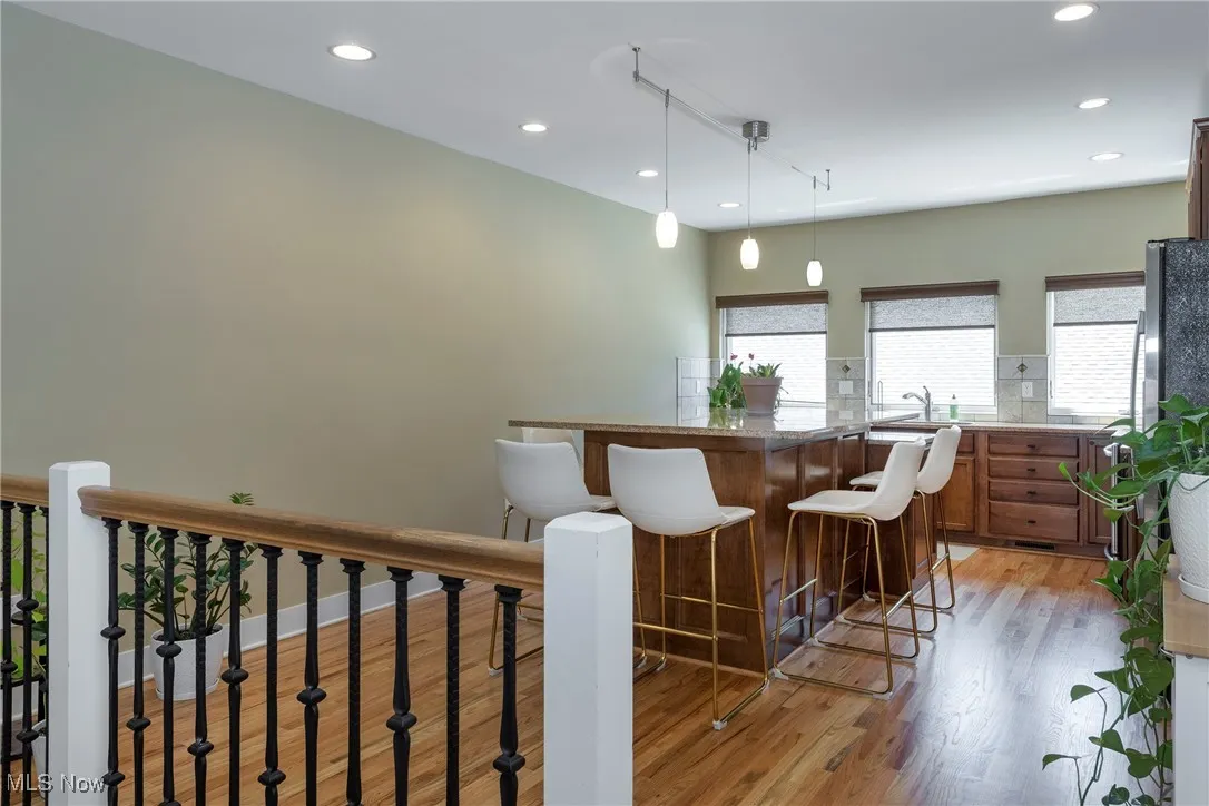 Kitchen featuring light wood finished floors, a breakfast bar, recessed lighting, a kitchen island, and hanging light fixtures
