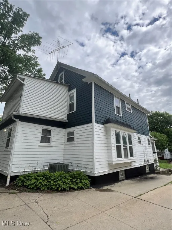 View of side of home with a central AC unit