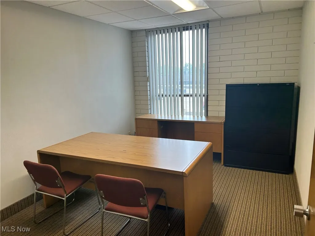Carpeted office with a paneled ceiling