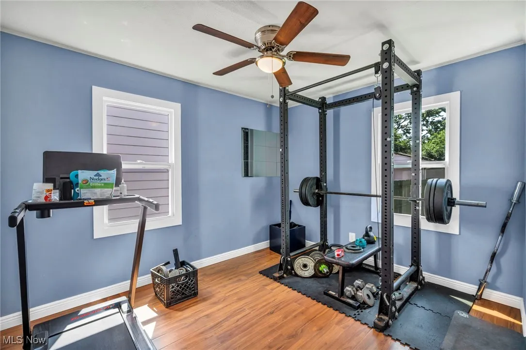 Workout room with ceiling fan and wood finished floors