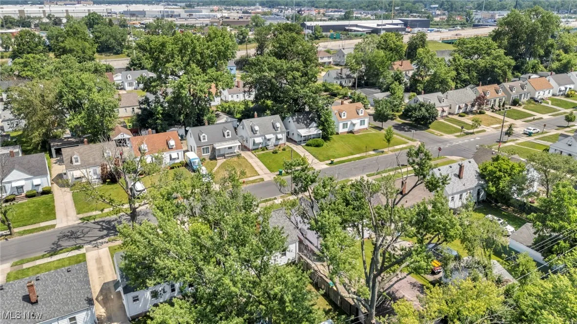 Aerial view of property and surrounding area featuring nearby suburban area