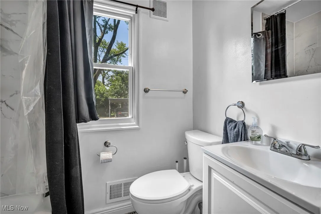 Full bath featuring vanity and toilet