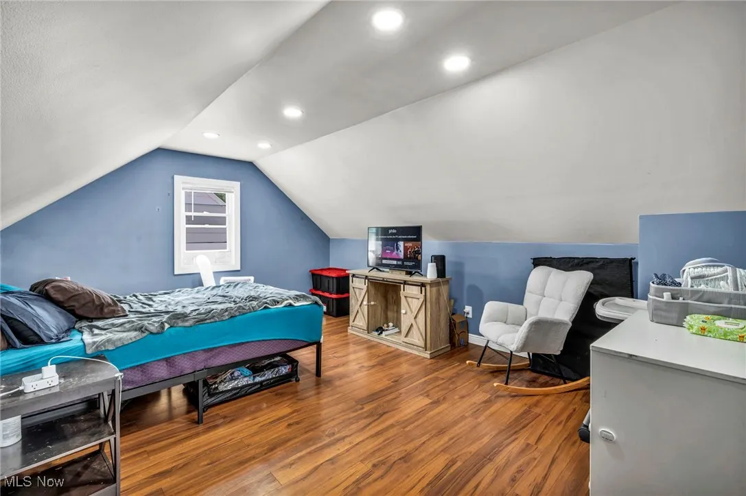 Bedroom with wood finished floors, recessed lighting, and vaulted ceiling