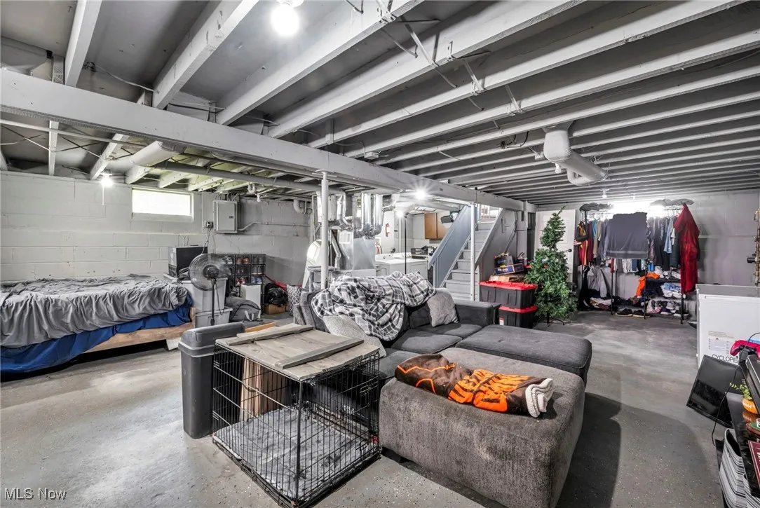 Basement featuring stairs, electric panel, and independent washer and dryer