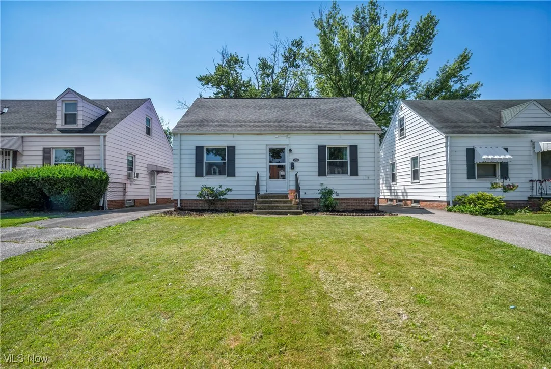 View of front of house featuring a front lawn, asphalt driveway, and entry steps
