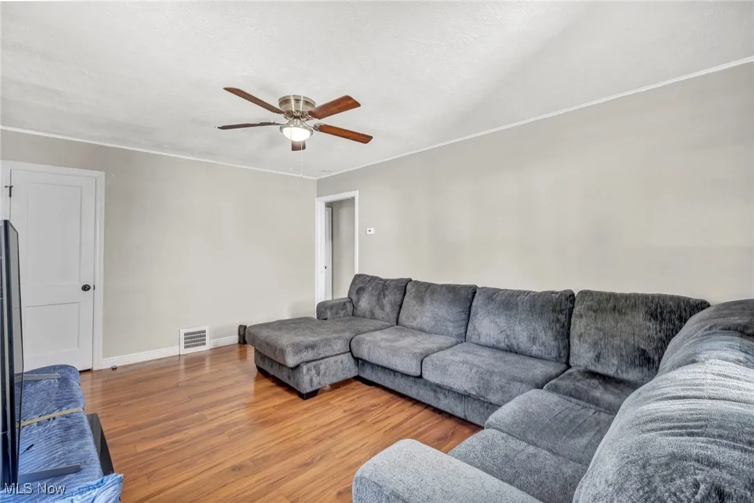 Living area featuring wood finished floors and a ceiling fan