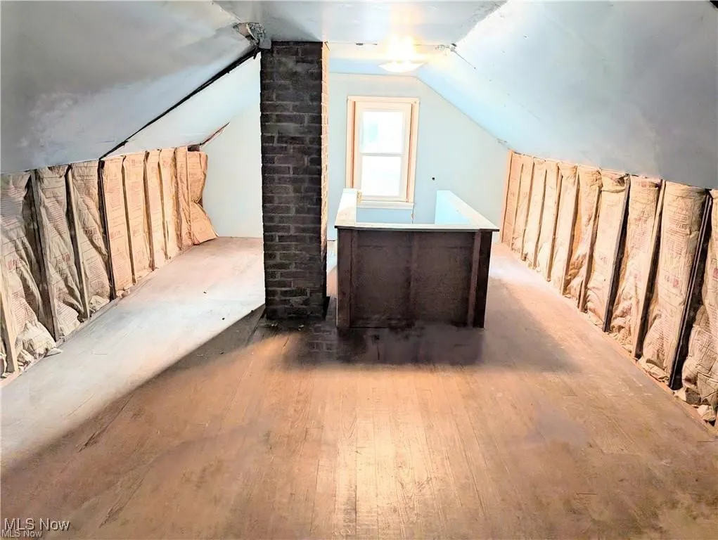 Additional living space with hardwood / wood-style flooring and lofted ceiling