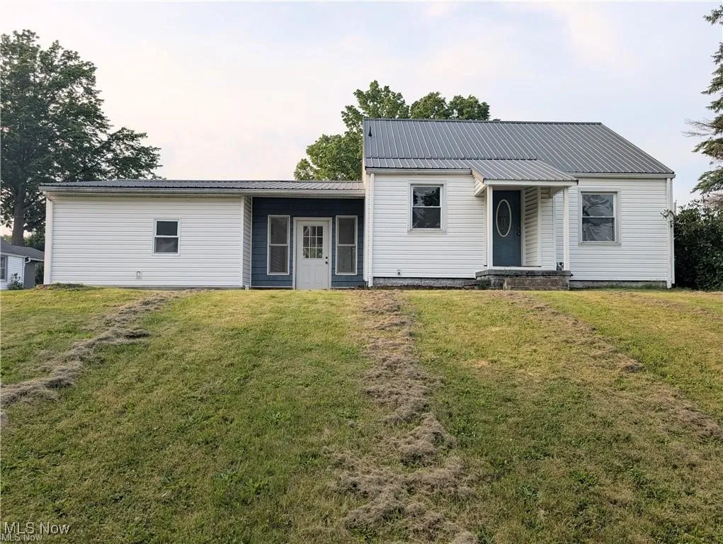 View of front of home with a front lawn and a metal roof