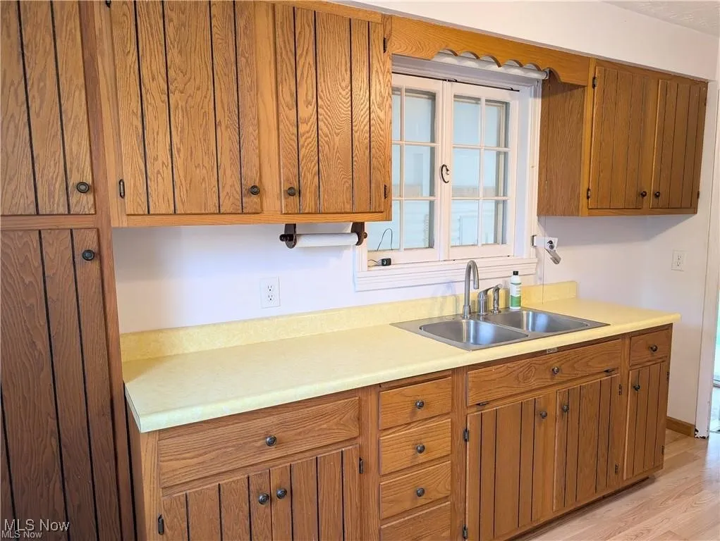 Kitchen featuring light countertops, brown cabinetry, and light wood-type flooring