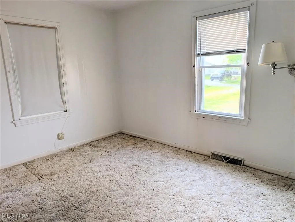 Spare room featuring carpet floors and baseboards