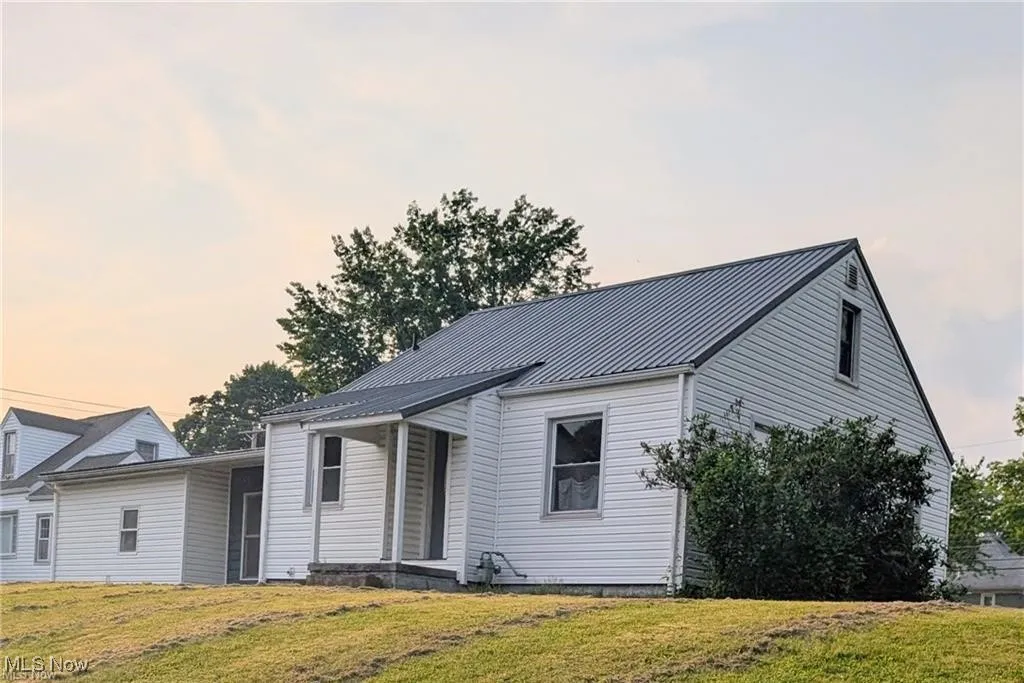 View of front of property with a front lawn, a metal roof, and a standing seam roof