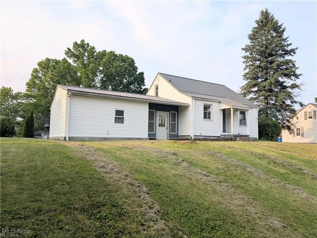 view of house with a yard and a metal roof
