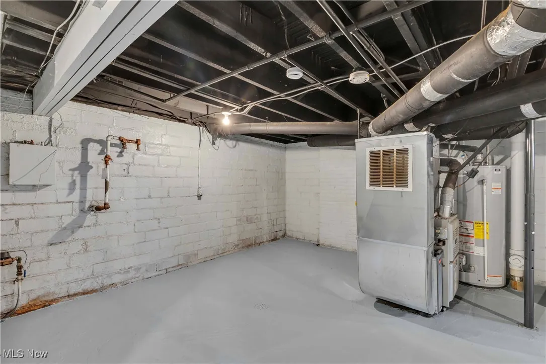 Unfinished basement featuring water heater and heating unit