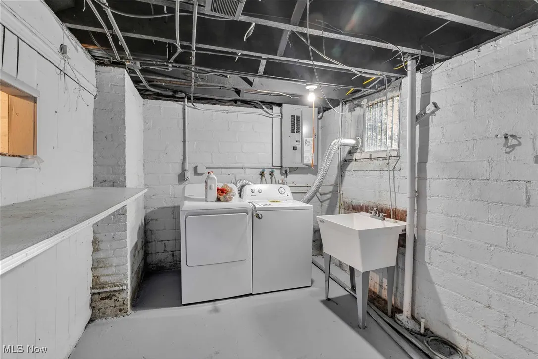 Below grade area featuring electric panel and washing machine and dryer