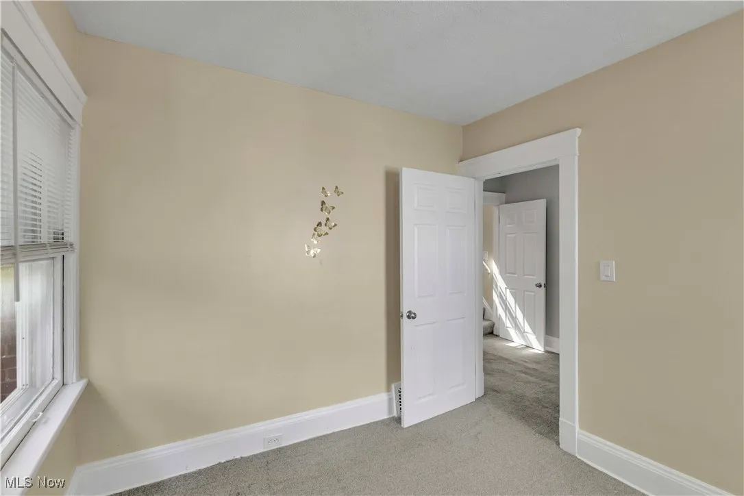 Carpeted empty room with baseboards