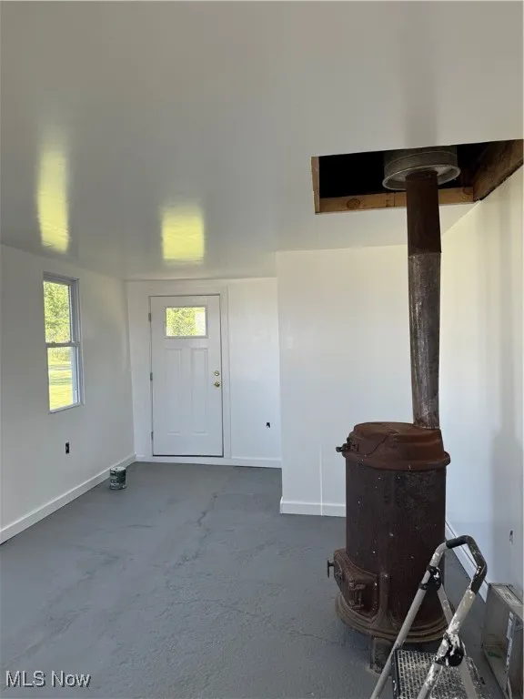 Entrance foyer with baseboards and dark carpet
