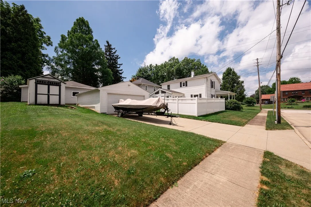 View of back yard with a storage shed and a detached garage