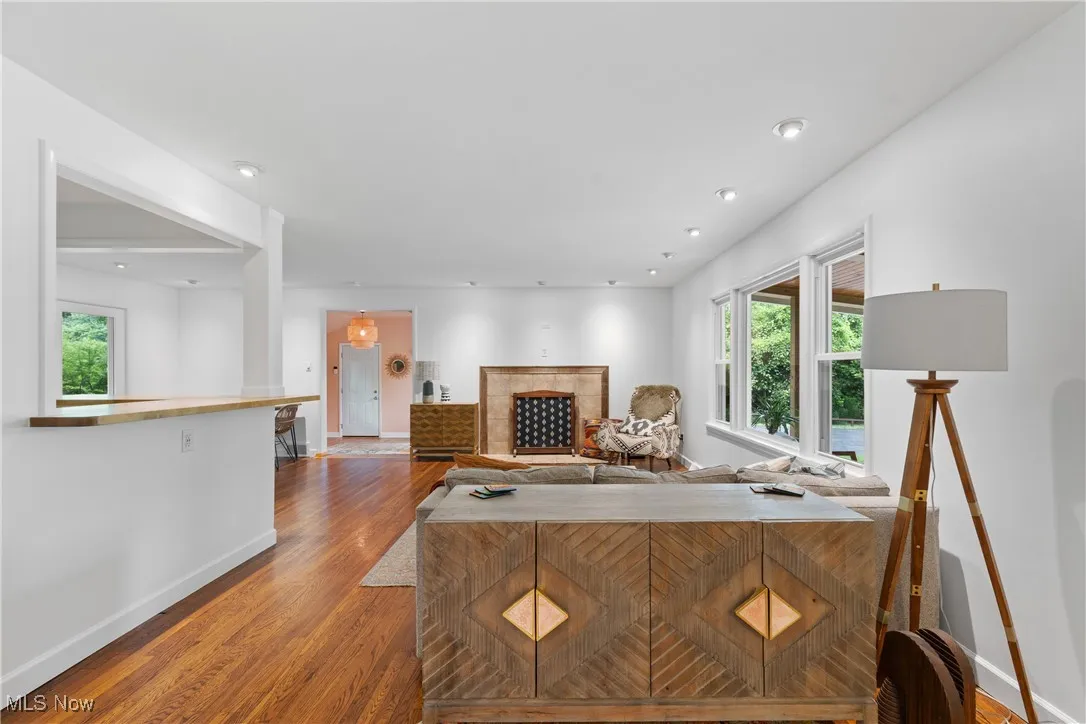 Living area featuring wood finished floors, plenty of natural light, and a tile fireplace