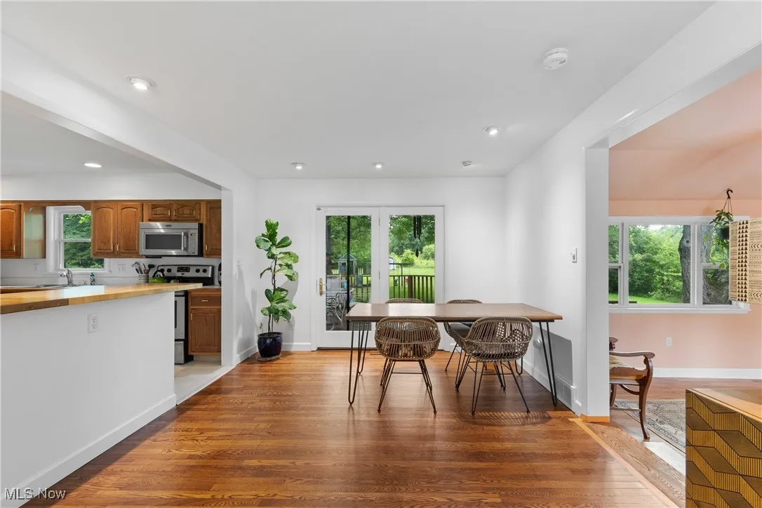 Dining space with plenty of natural light, wood finished floors, and recessed lighting
