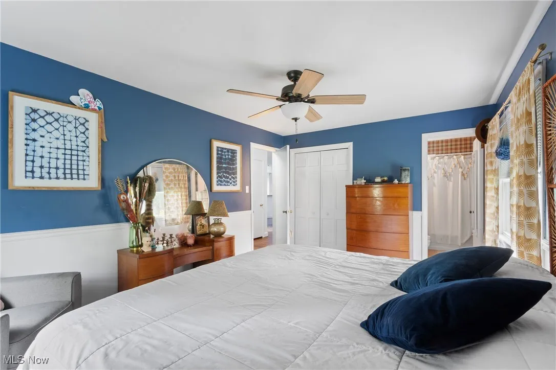 Bedroom featuring wainscoting, a closet, and ceiling fan