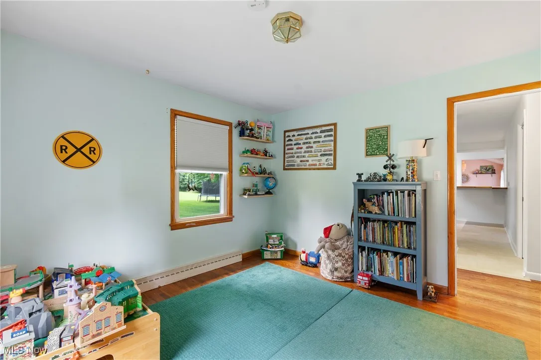 Recreation room with baseboard heating and wood finished floors