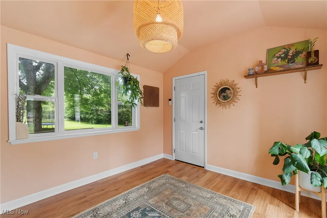 Foyer featuring lofted ceiling, wood finished floors, and a chandelier