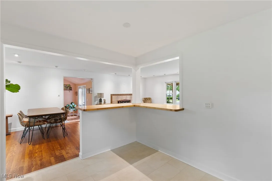 Kitchen featuring wooden counters, a peninsula, and a fireplace