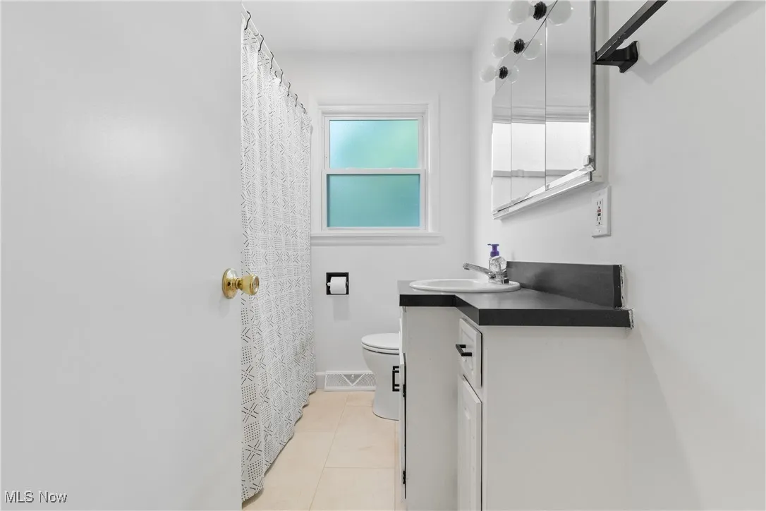 Bathroom featuring vanity, tile patterned flooring, and a shower with shower curtain